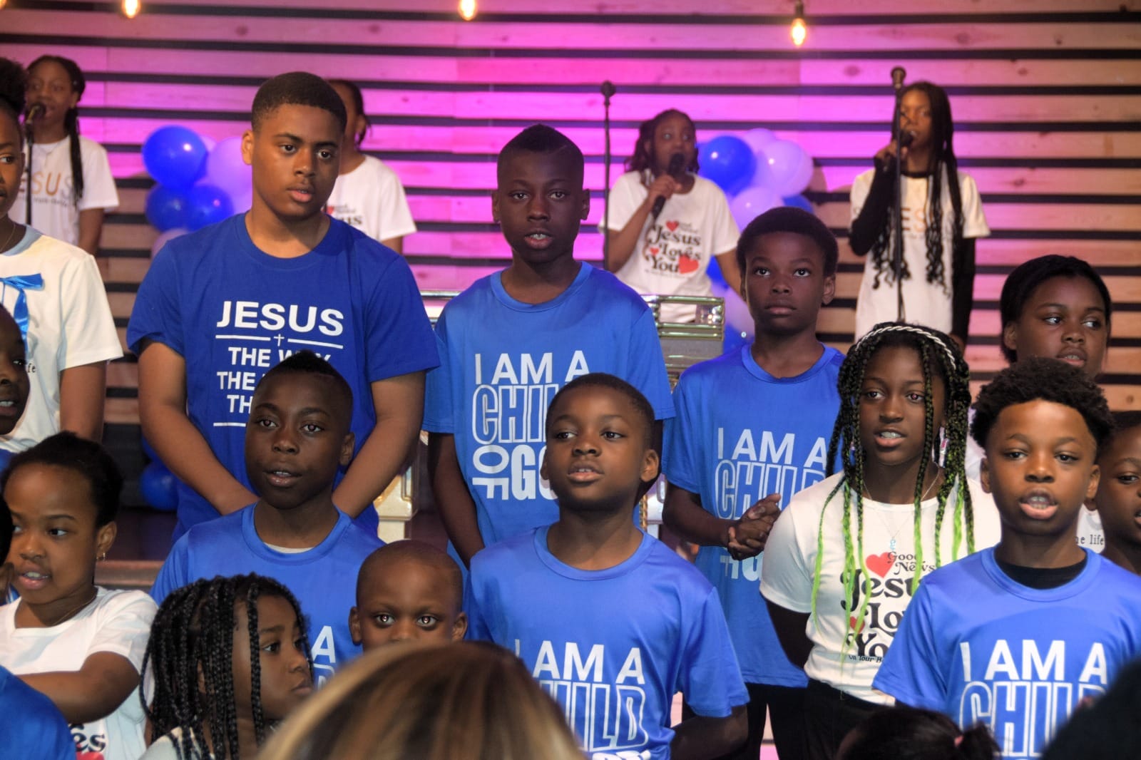 Children singing together on stage during the Children’s Day service
