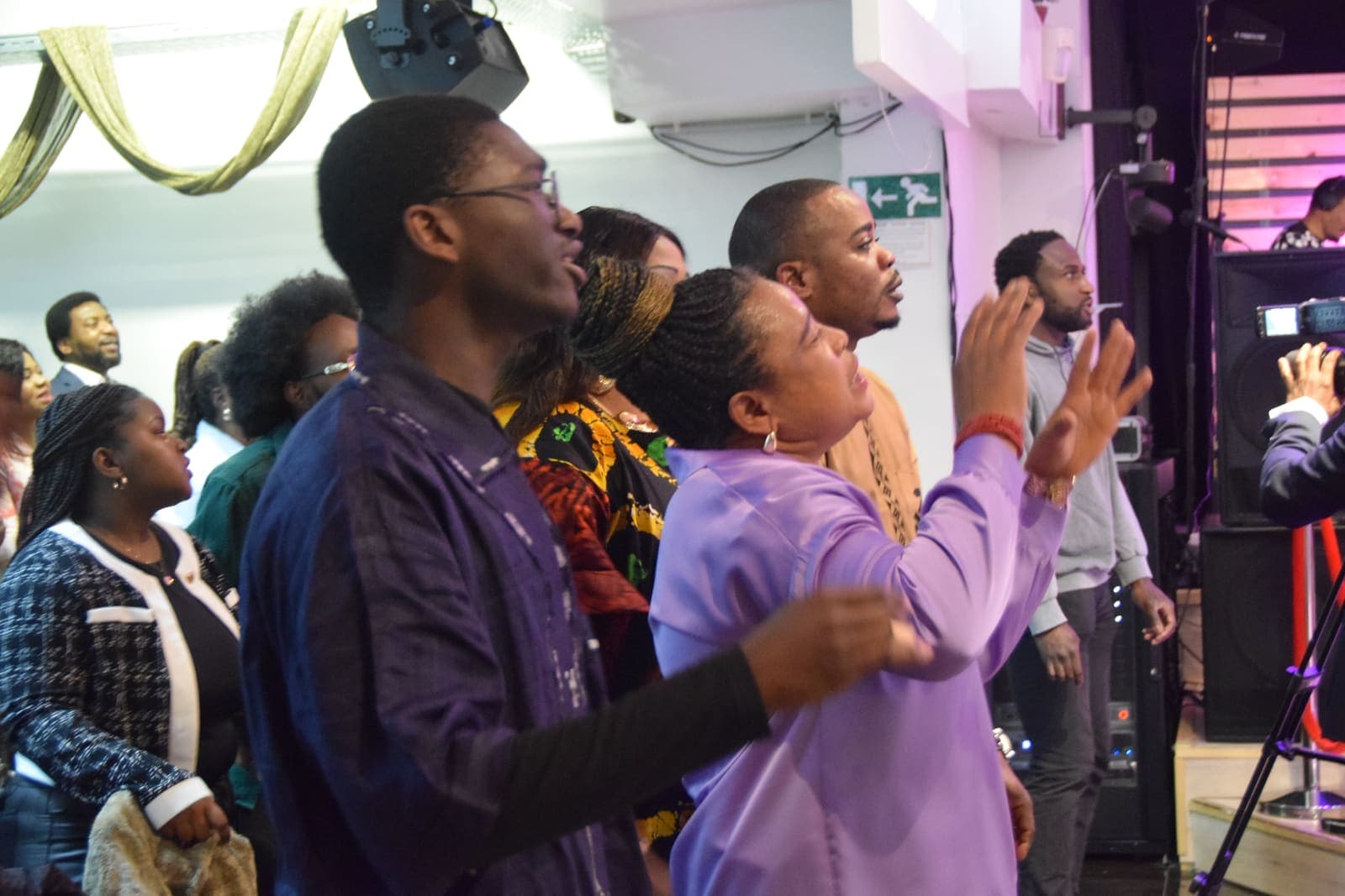 The congregation worshipping with hands raised during a service