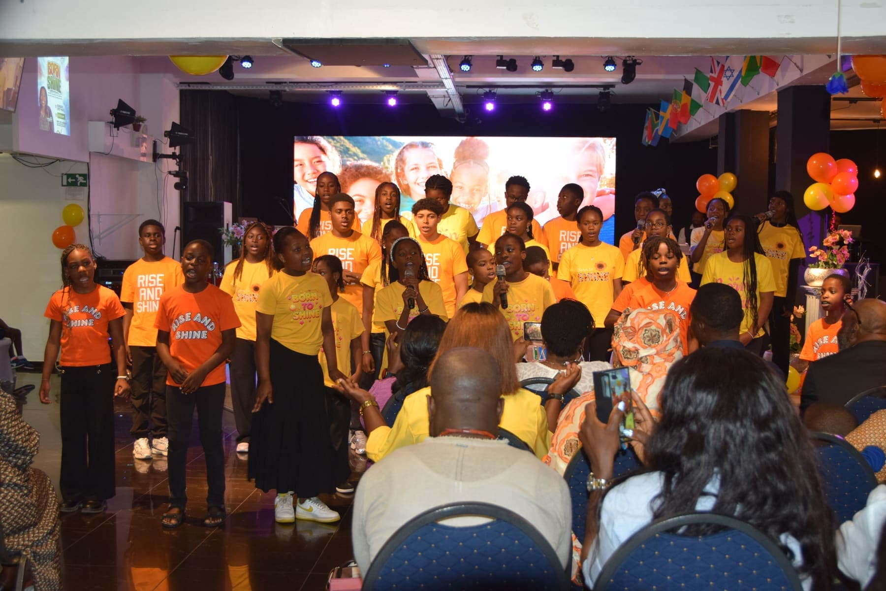The children’s group on stage seen from the back of the hall