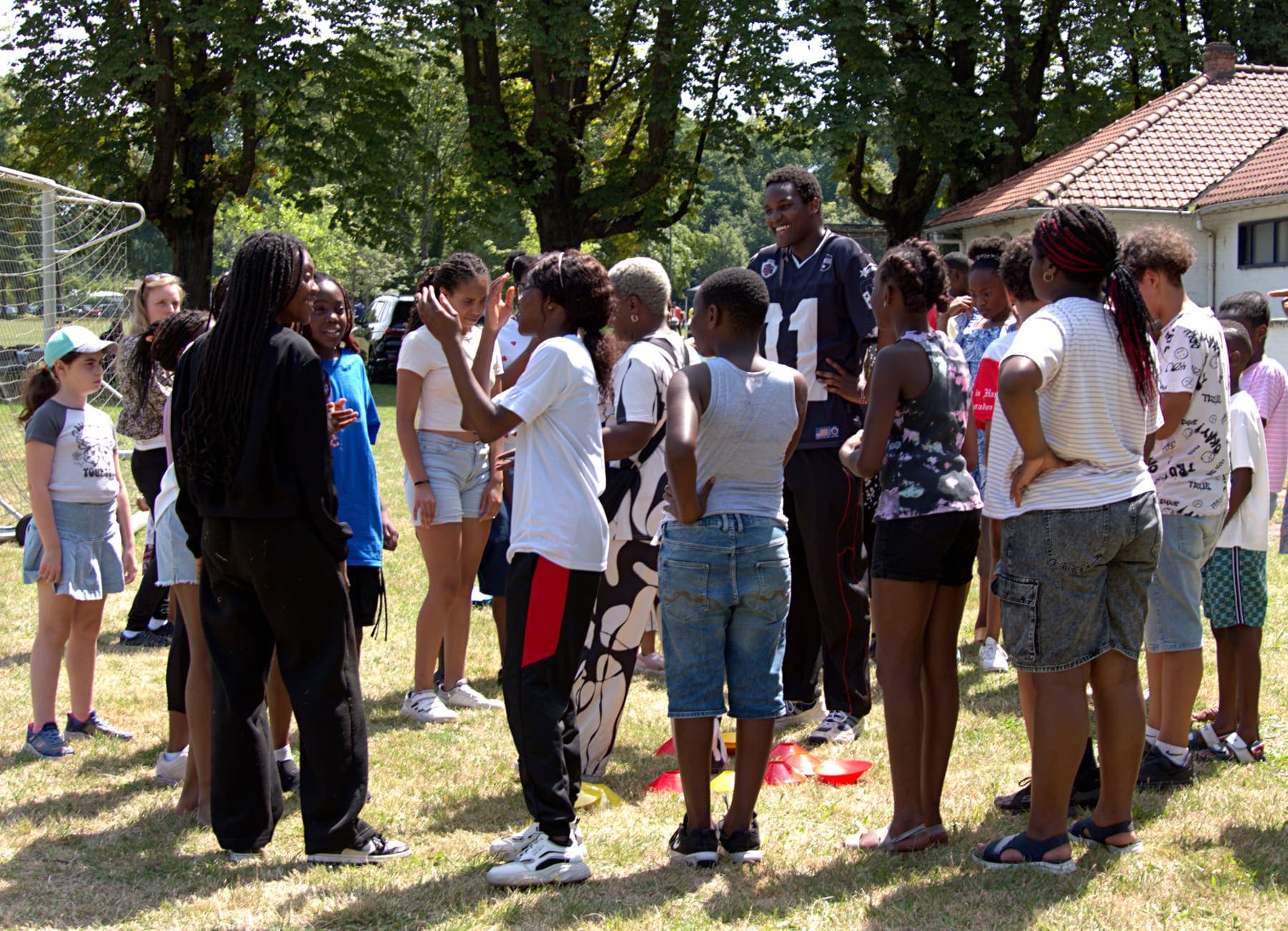 Members gathered together under the trees at the barbecue