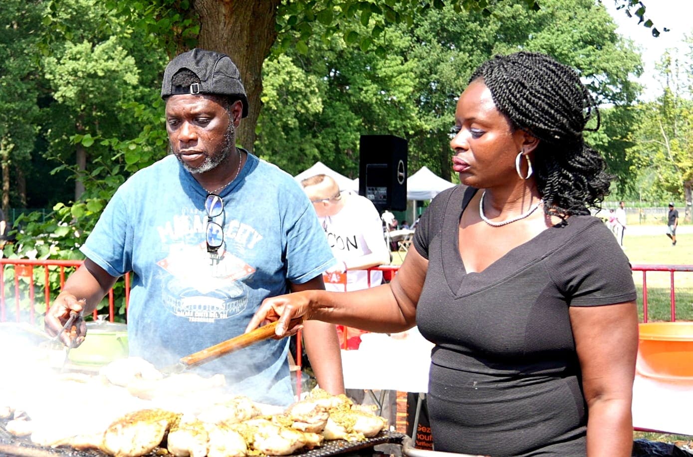 Two members serving food together at the grill