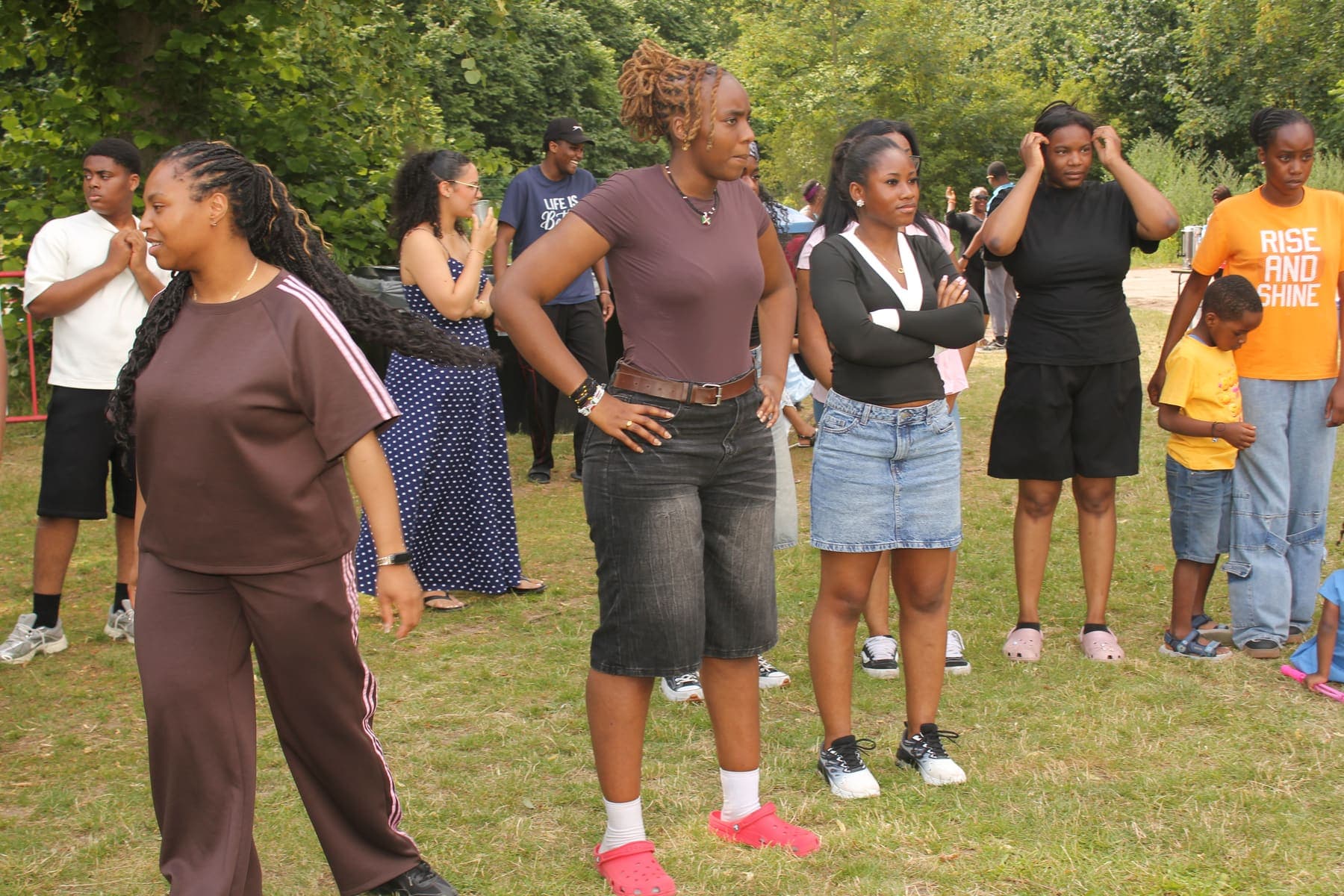 A group of members standing and talking on the grass