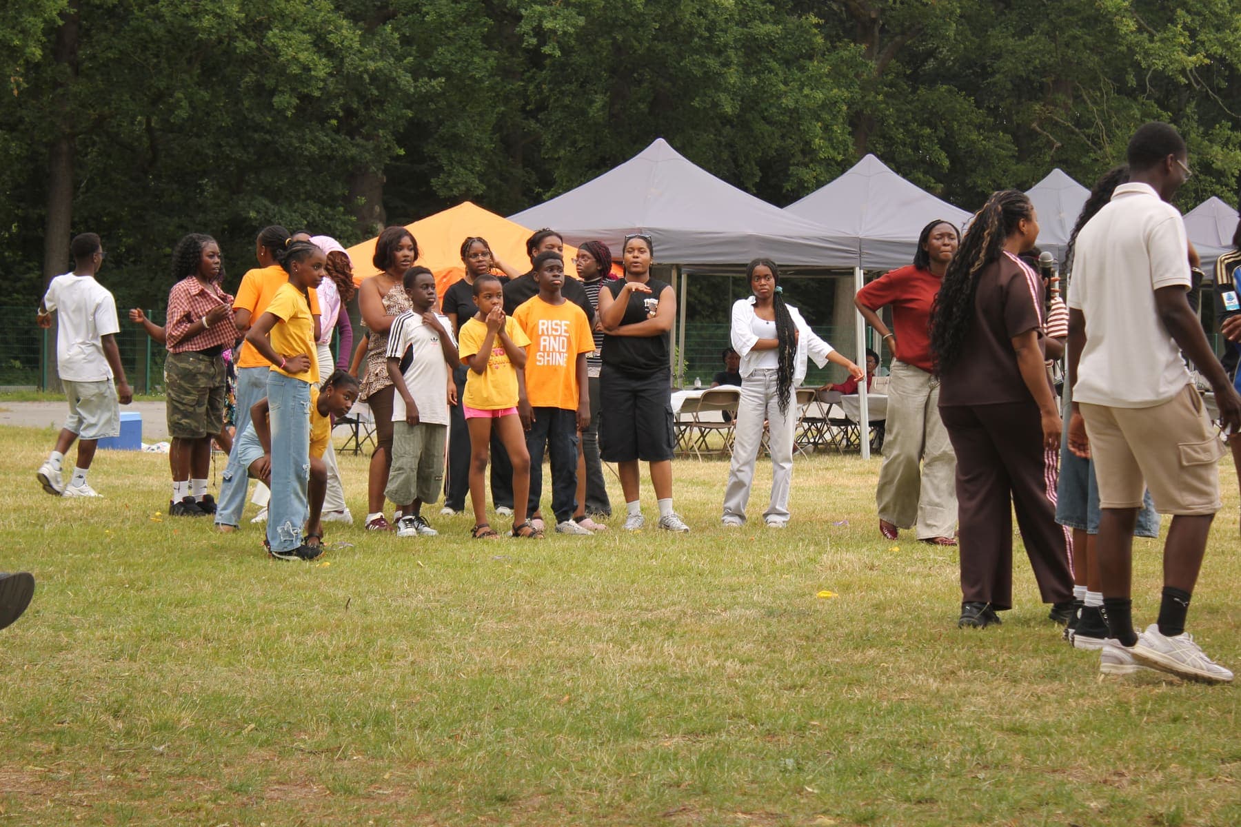 A wide view of the gazebos and members gathered in the park