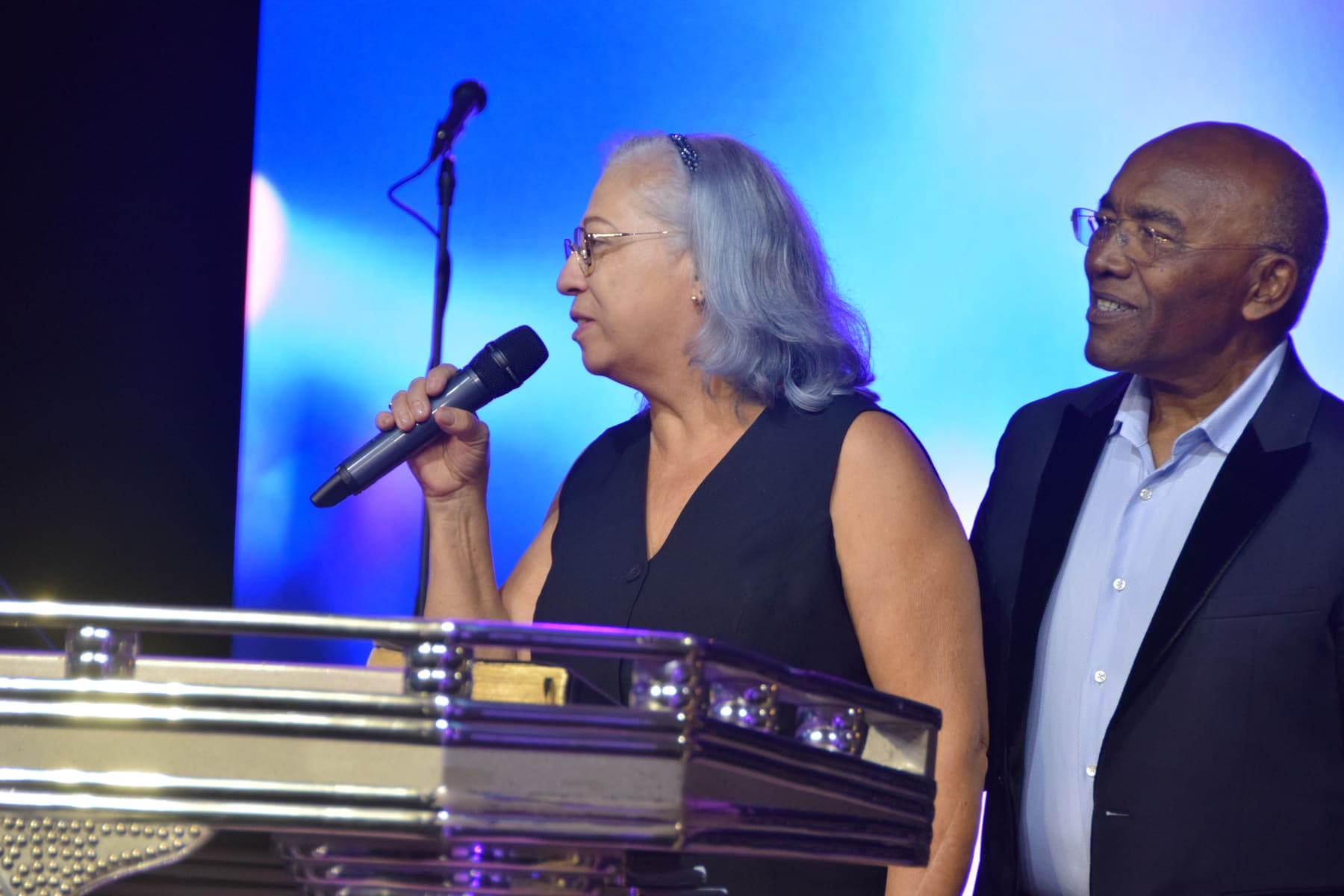 A couple ministering together at the podium