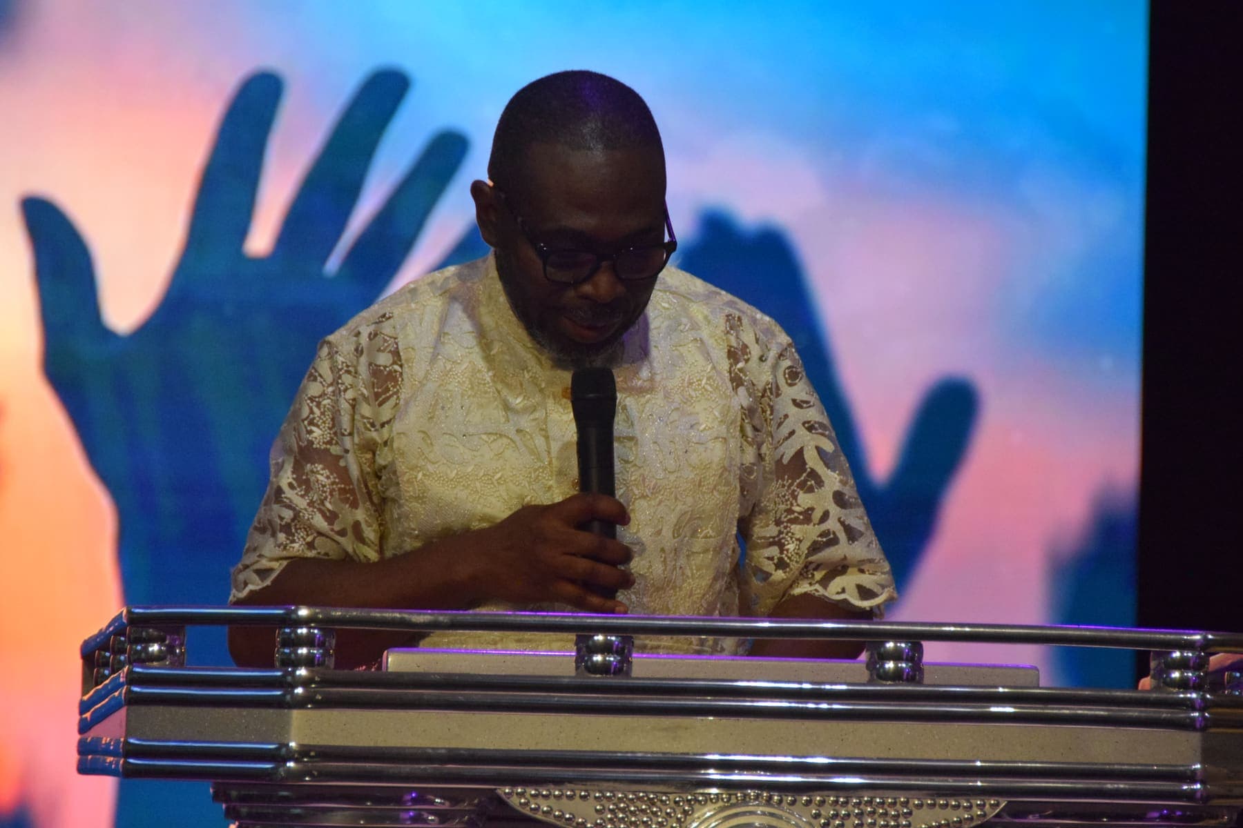 A minister leading prayer at the podium