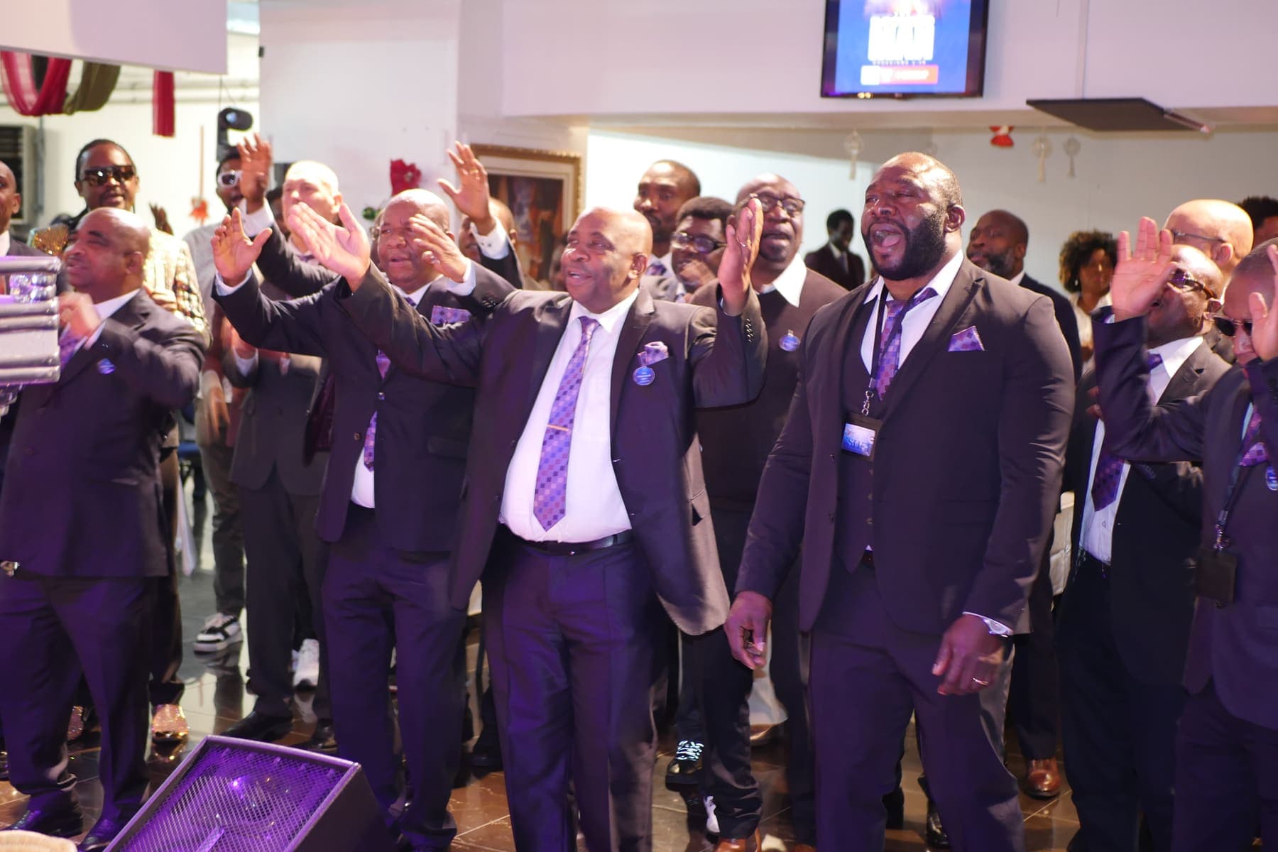 Men worshipping with hands raised on Men’s Day