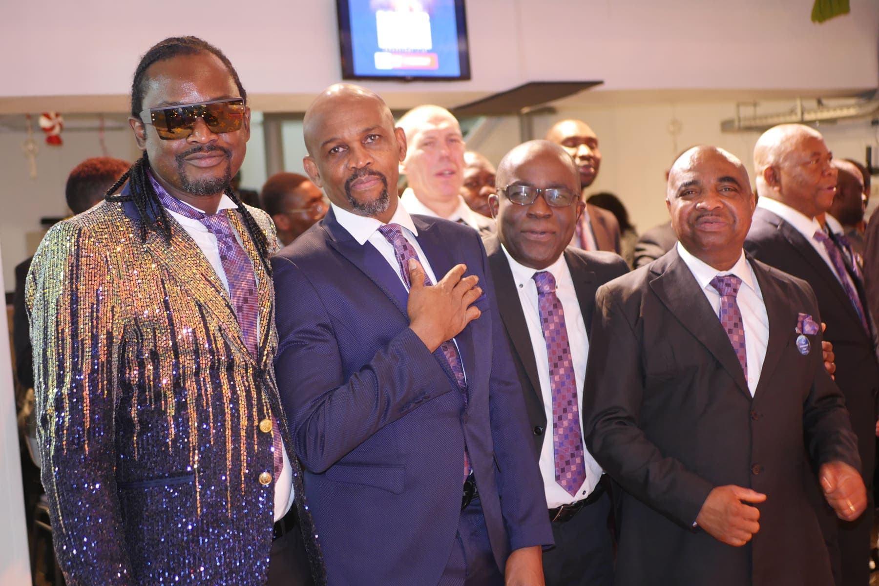 Men standing together in suits on Men’s Day