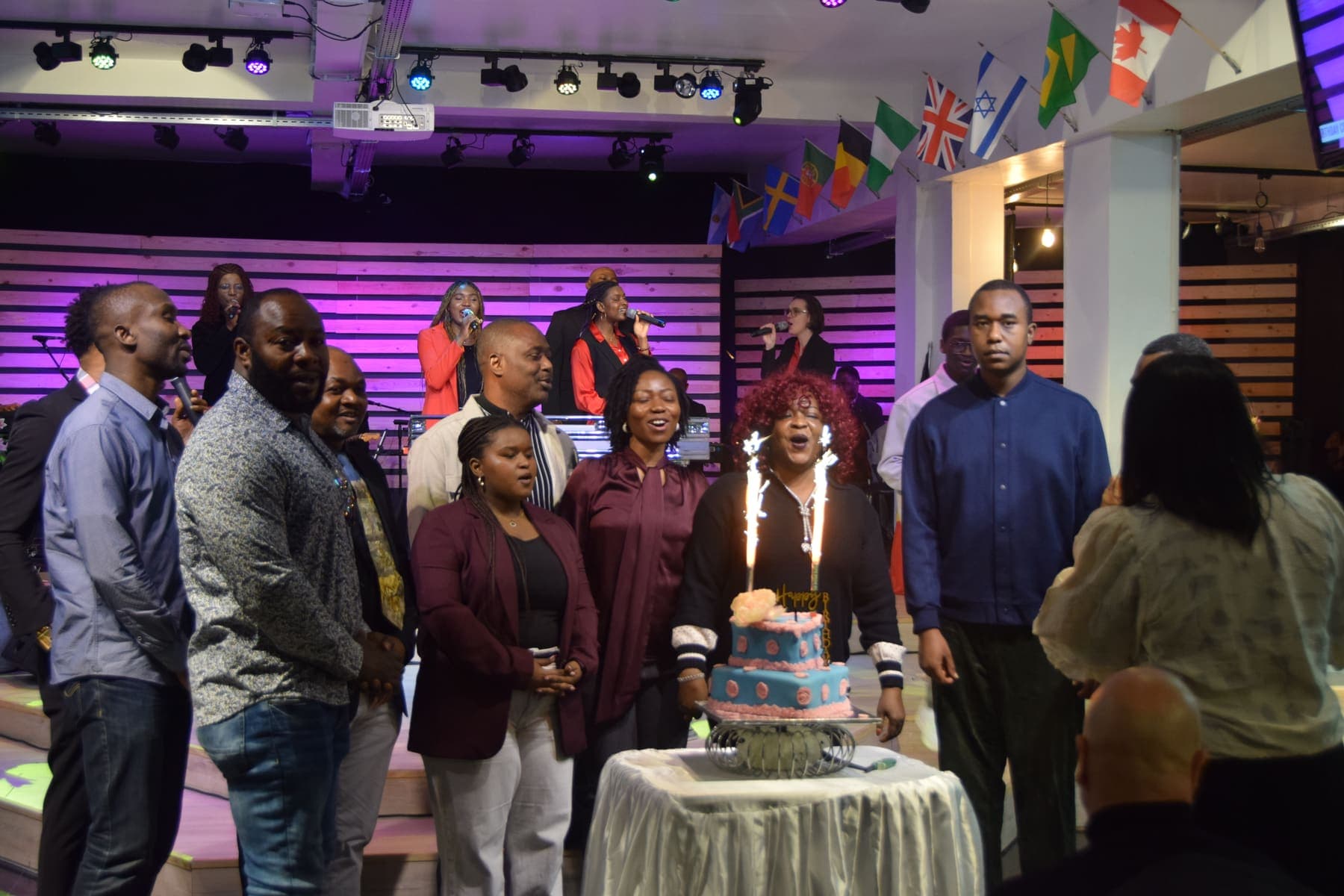 Members standing together at the cake during the thanksgiving celebration