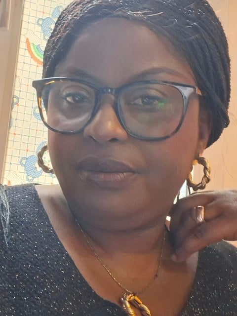 A children’s church teacher in glasses and gold hoop earrings