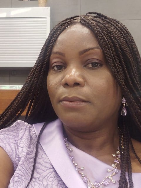 A children’s church teacher in braids, smiling quietly